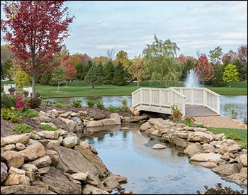  6 x 20 Straight Spindle Rail Bridge shown with Ivory Vinyl Railings, Madiera Trex Deck, Continuous Handrail, 36" High Rails, and Ivory Vinyl Beam Wrap.